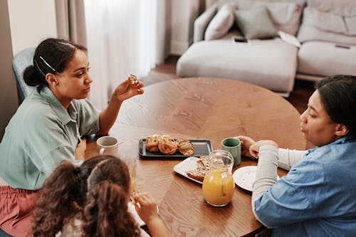 A Happy Family Talking while Having Breakfast