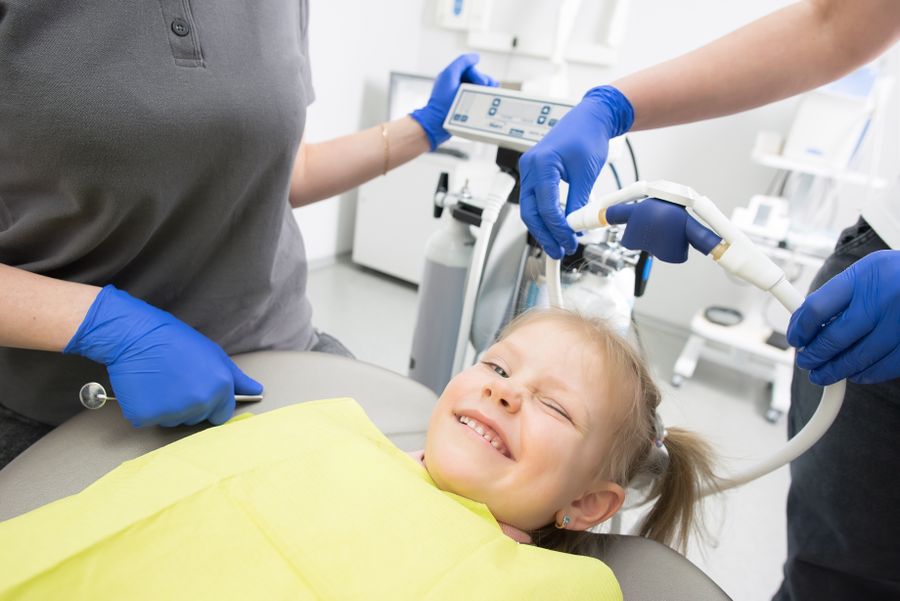 Child smiling in a dental chair during pediatric dentistry visit