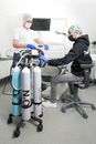 Man in Black Sitting on Black Chair near Patient in Dental CHair