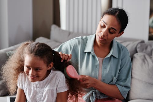 Free Woman Combing her Daughter's Hair Stock Photo