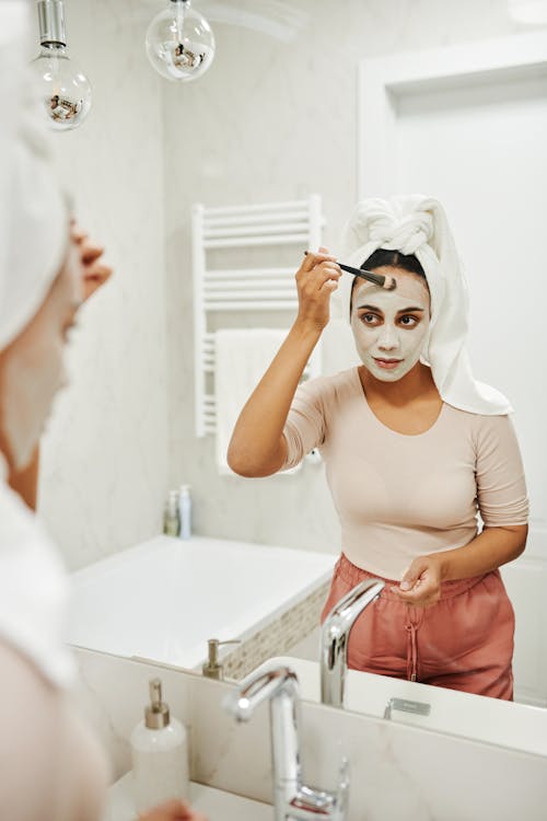 A Woman Putting a Clay Mask on Her Face