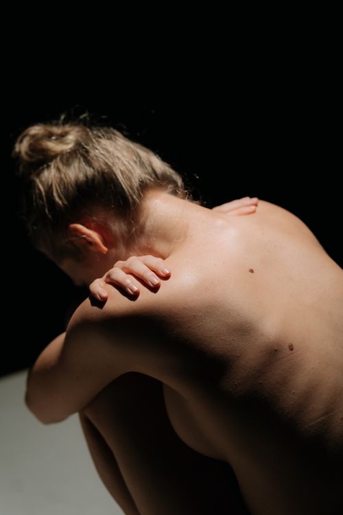 Free A captivating artistic nude photo with dramatic lighting and shadow contrasts. Stock Photo