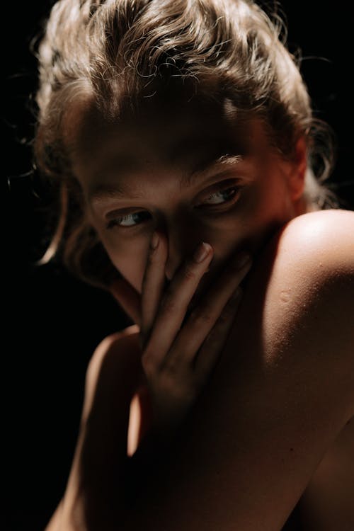 Free Close-Up Shot of a Woman Covering Her Mouth Stock Photo