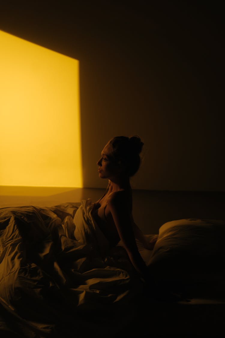 Topless Woman Sitting On Bed