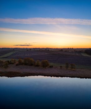 Serene aerial shot of agricultural land and water at sunset in Minnesota, USA.