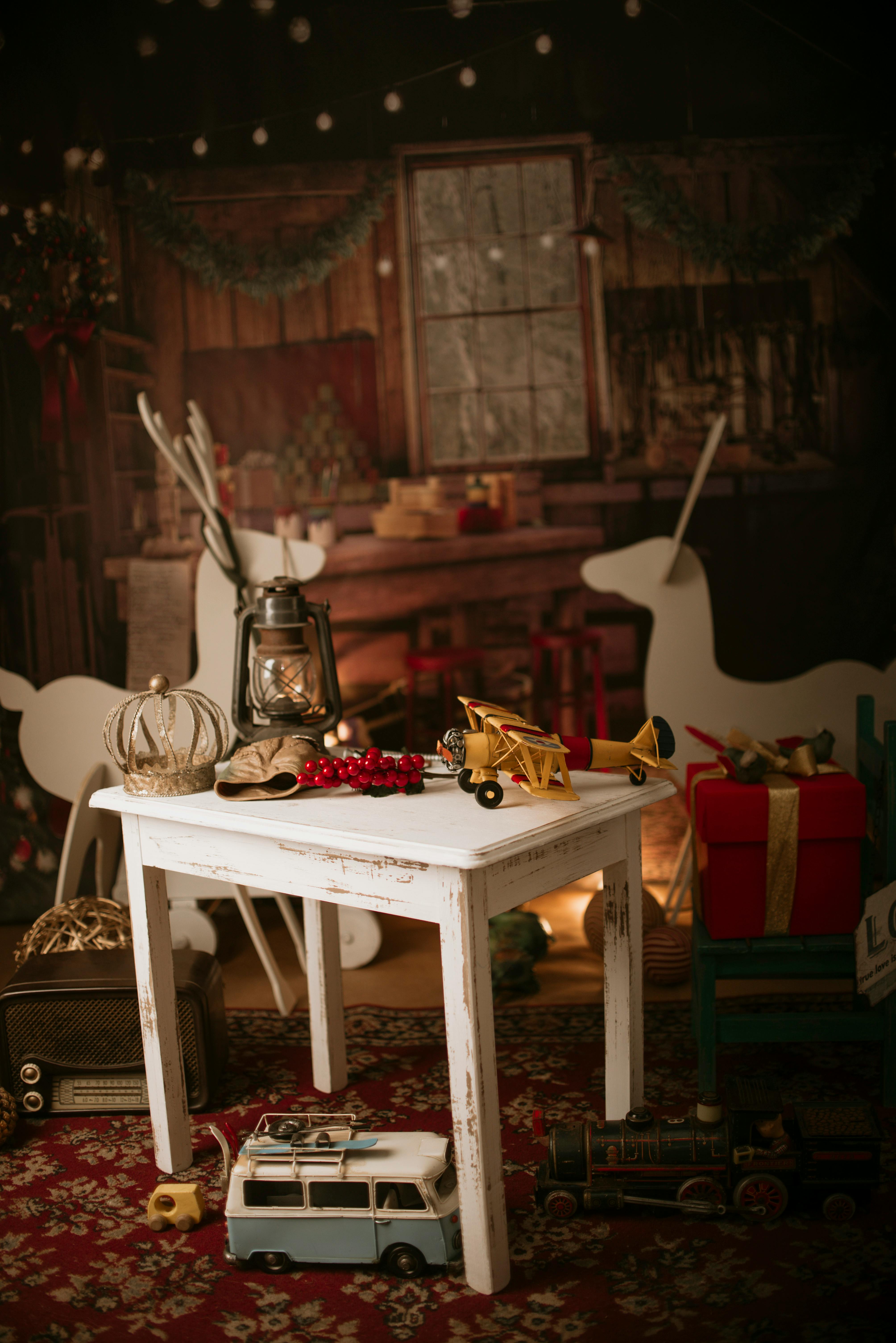 Warm and vintage Christmas setup featuring lantern, gifts, and toys indoors.