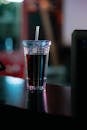 Clear Plastic Cup With Straw on Brown Wooden Table