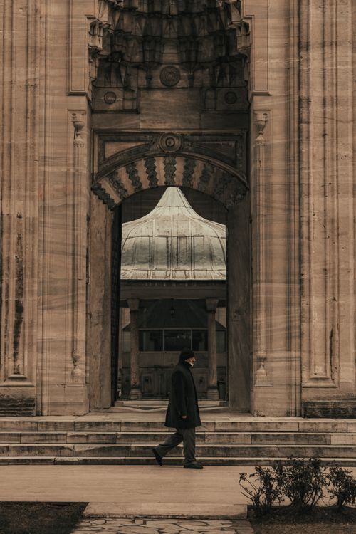 Free A person walks past a grand stone entrance in Istanbul, showcasing traditional architecture. Stock Photo