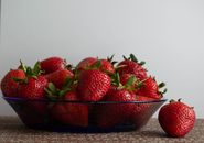 A vibrant close-up image of ripe red strawberries in a glass bowl, perfect for summer themes.