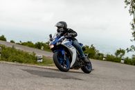 A Person Riding a Motorcycle while Strolling on the Road