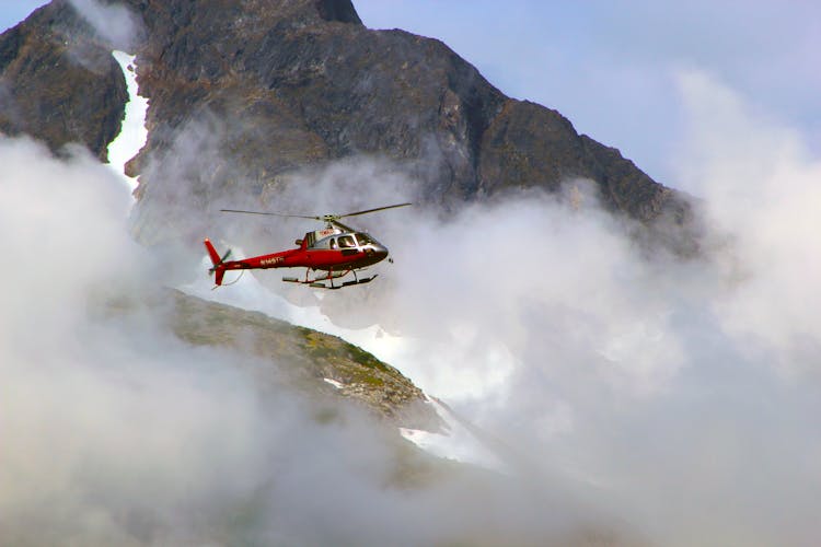 Red Helicopter On Top Of Foggy Mountain