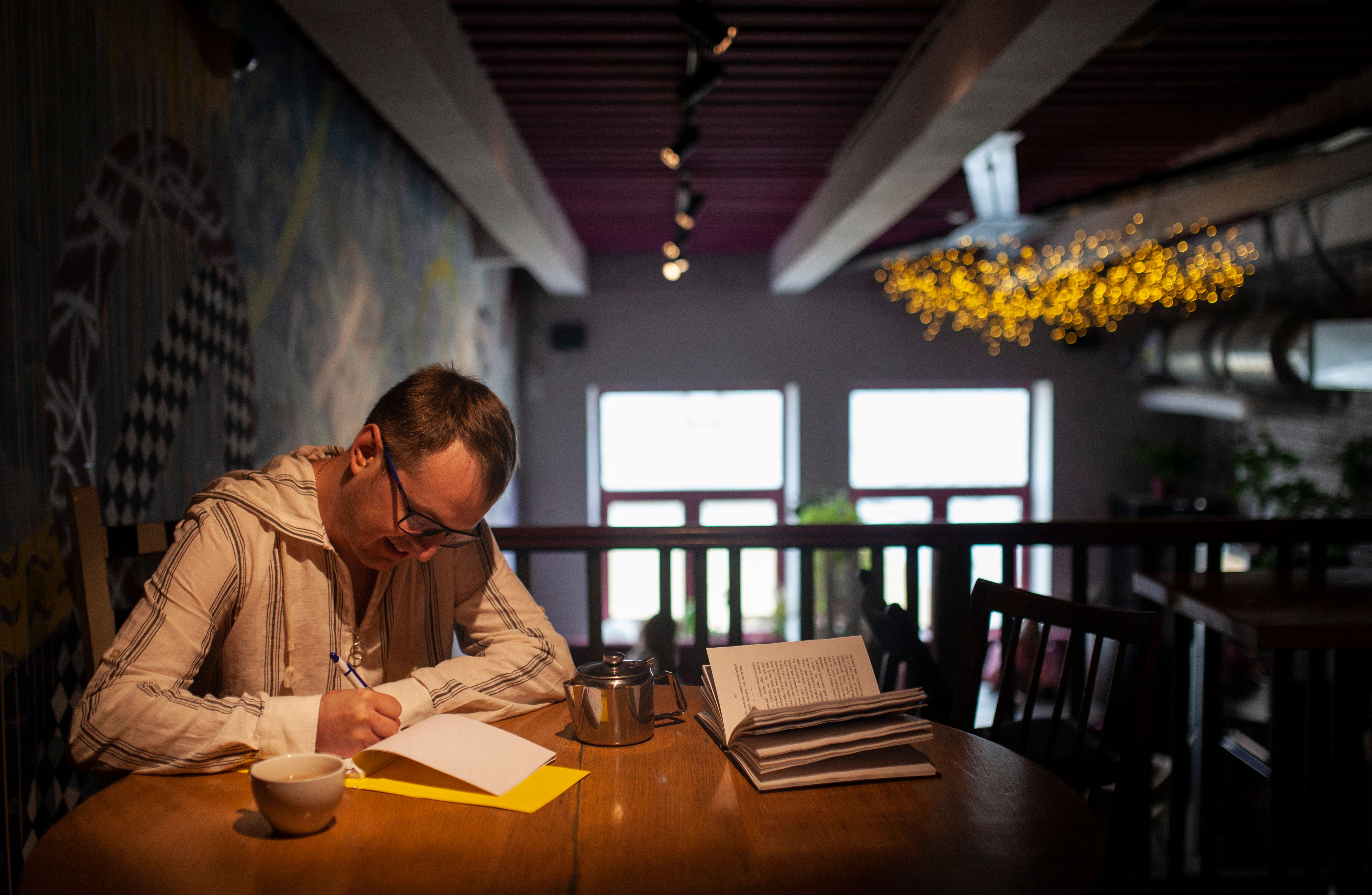 Photo of a Man Writing on a Notepad · Free Stock Photo