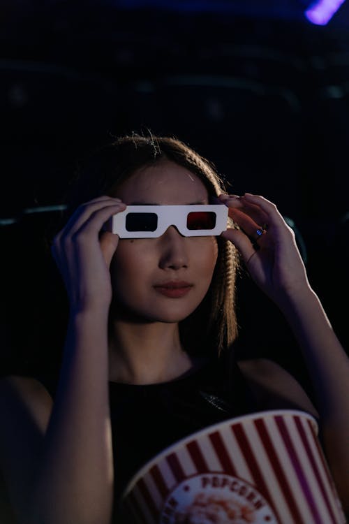 Free A Woman Touching the 3d Glasses on Her Face Stock Photo