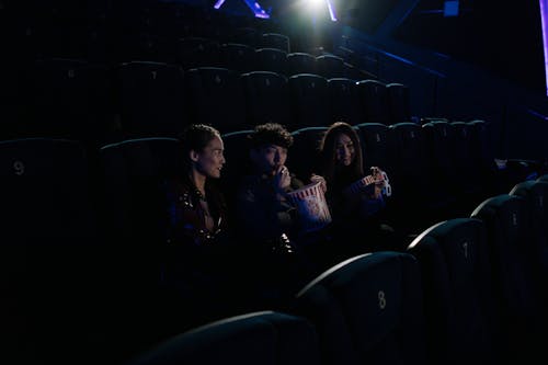 Free Two Women and a Man at a Movie Theater Stock Photo