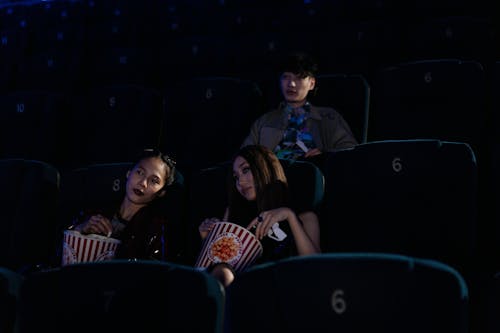 Group of Friends Sitting on a Cinema while Seriously Watching Movie