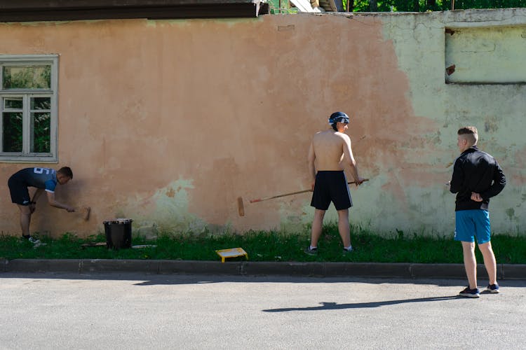 Young Men Painting A House Facade And A Wall 