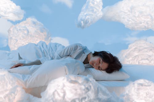 Free Photo of a Woman Sleeping Near Fluffy Clouds Stock Photo