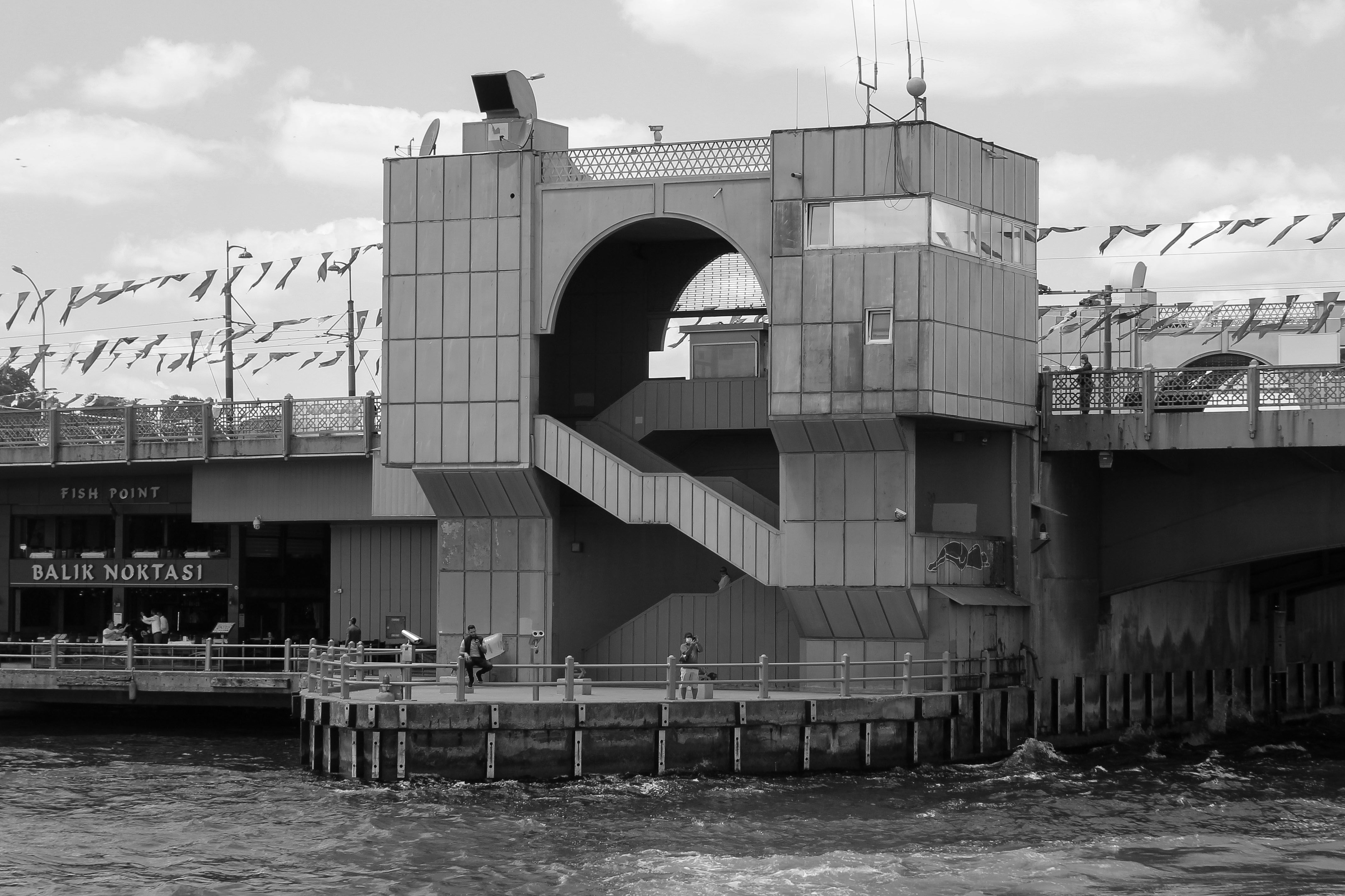 Yapay Zeka ve Örümcek Adam: Büyük Güç, Büyük Sorumluluk - Black and white image of coastal architecture in Türkiye with a bridge and waterfront.