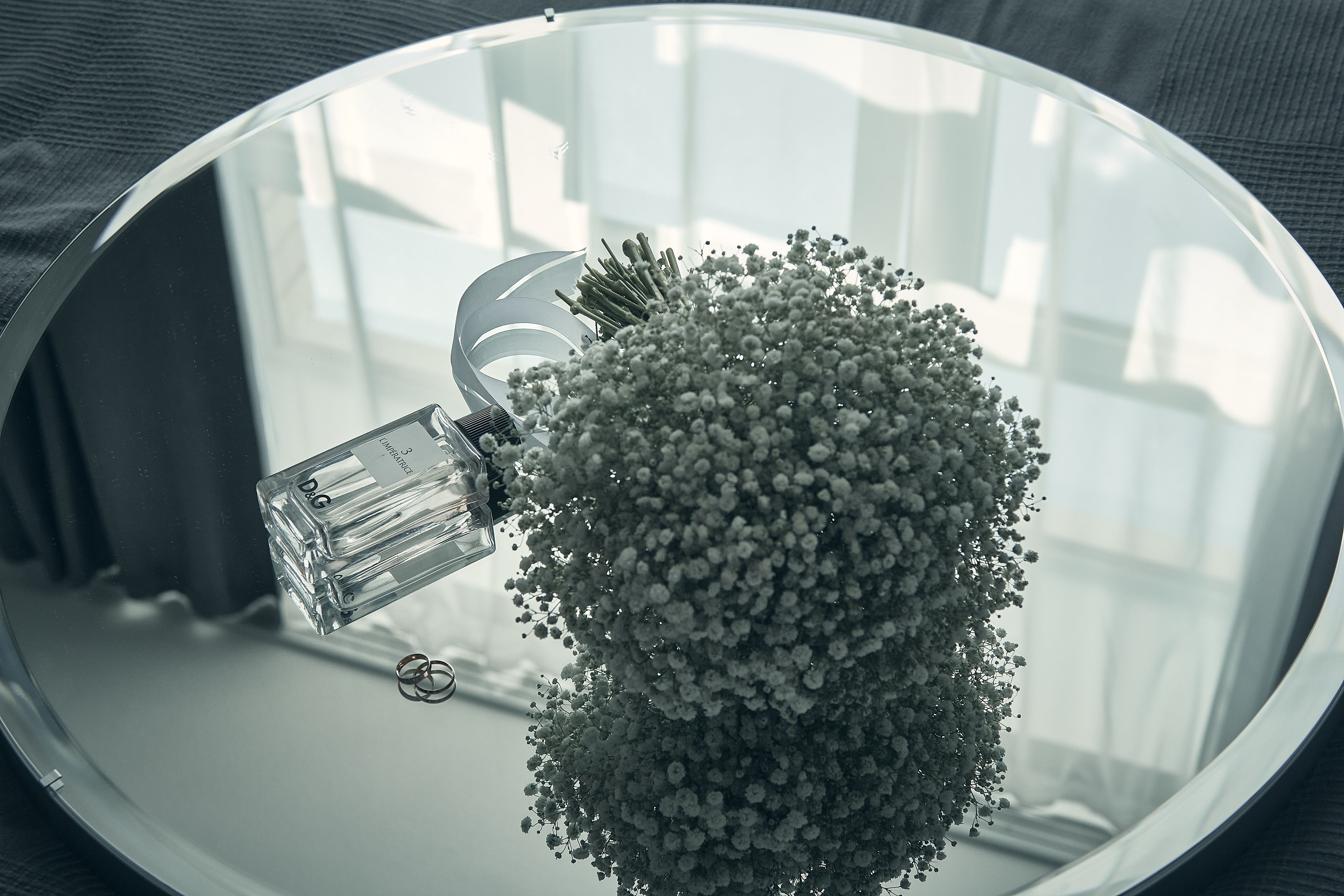 Wedding rings and a soft bouquet photographed as a small detail.