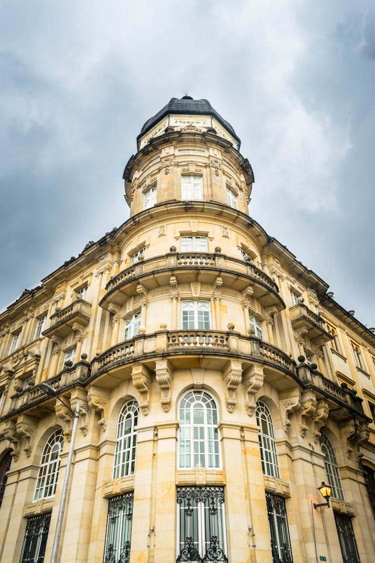 A Low Angle Shot Of A Concrete Building Under The Cloudy Sky