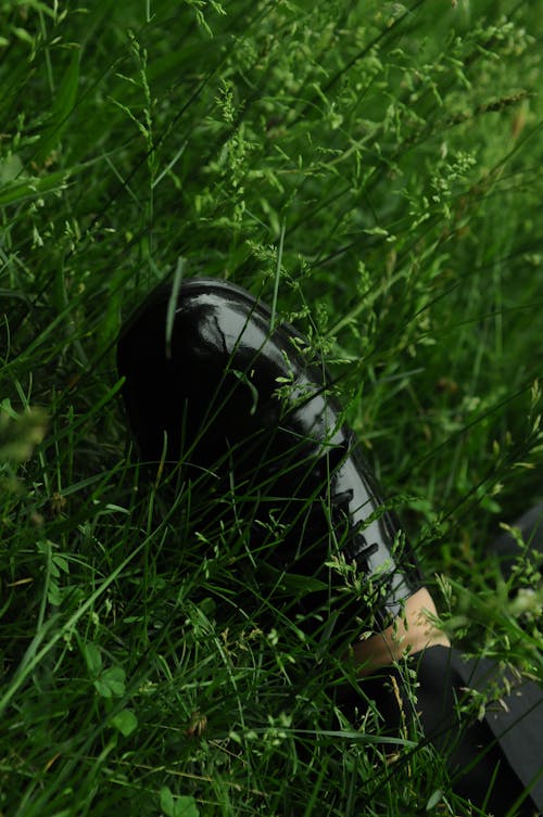 Free Person's Foot Wearing a Black Leather Shoe Near the Grass Stock Photo