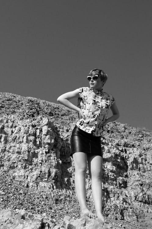 Grayscale Photo of Woman in Floral Shirt and Black Shorts