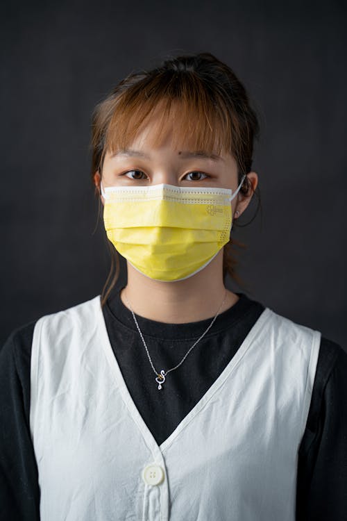 Portrait of a Woman Wearing a Yellow Face Mask