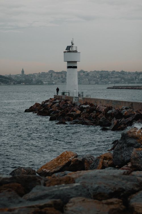 Free Serene view of a lighthouse on a rocky shore in Istanbul, Turkey at dusk. Stock Photo