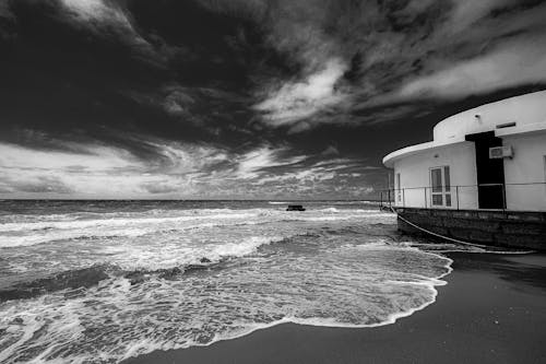 A Grayscale Photo of Sea Waves Crashing on Shore