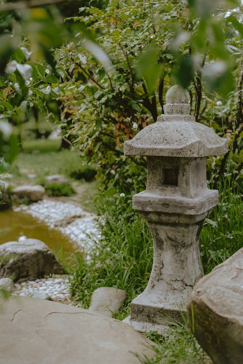 Free Peaceful Japanese garden scene featuring a traditional stone lantern and lush greenery. Stock Photo