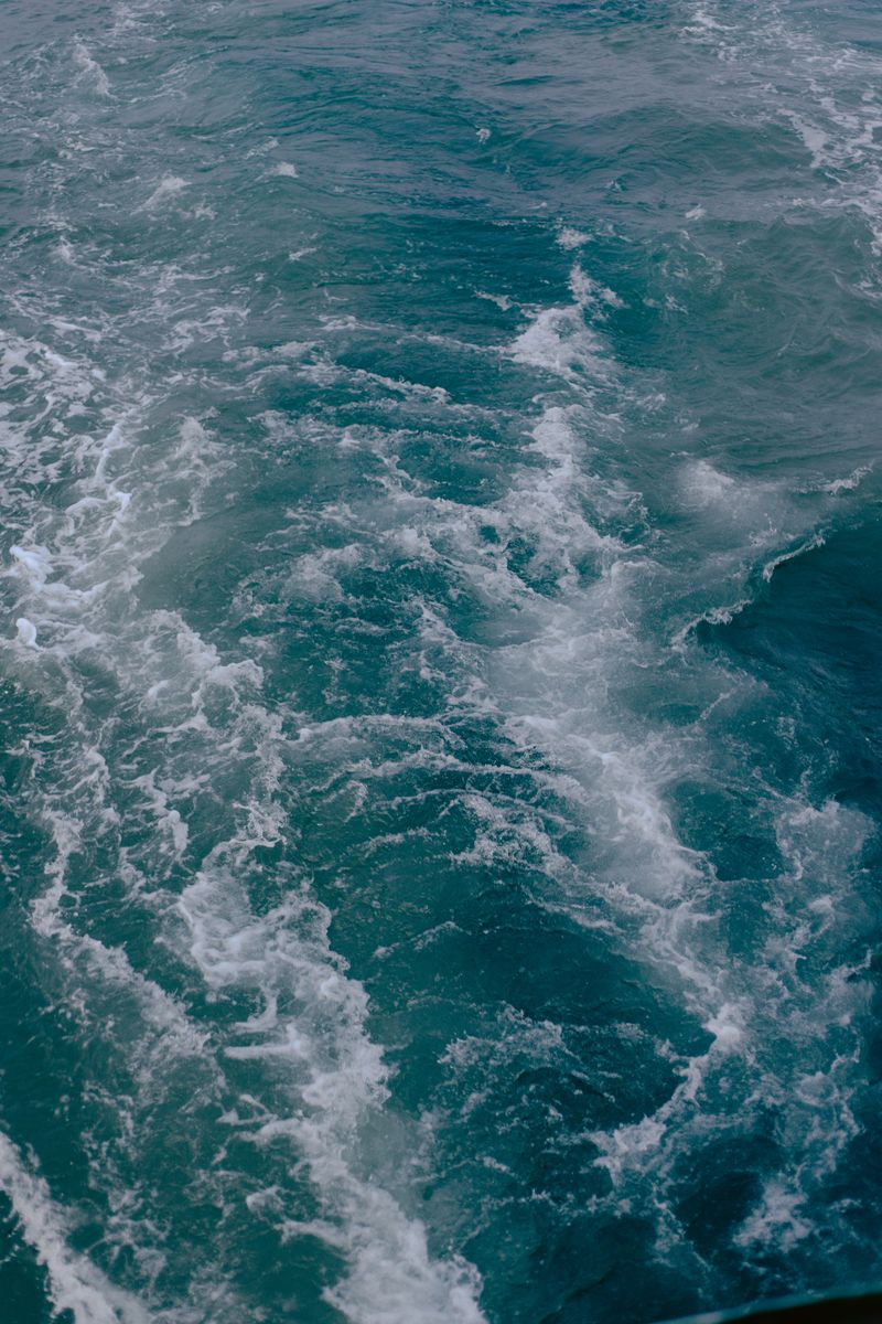 Captivating vertical shot of ocean waves in motion with visible seafoam texture.