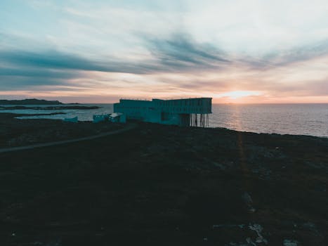 Captivating sunrise view of Fogo Island Inn beside the ocean, showcasing stunning skylines.