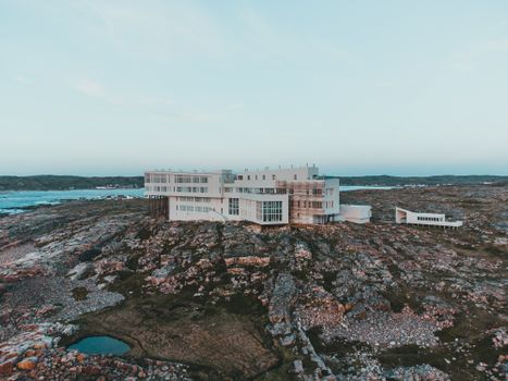 Aerial view of Fogo Island Inn set against the rocky Newfoundland coastline and Atlantic Ocean.