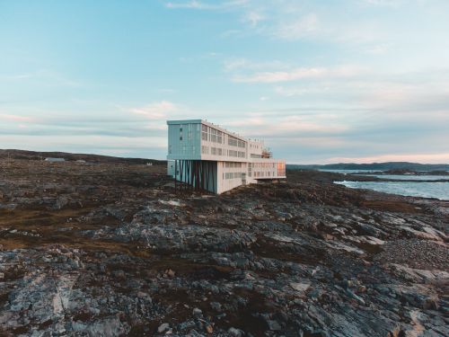 Free Stunning architectural hotel on Fogo Island's rocky coast with serene sky and landscape. Stock Photo
