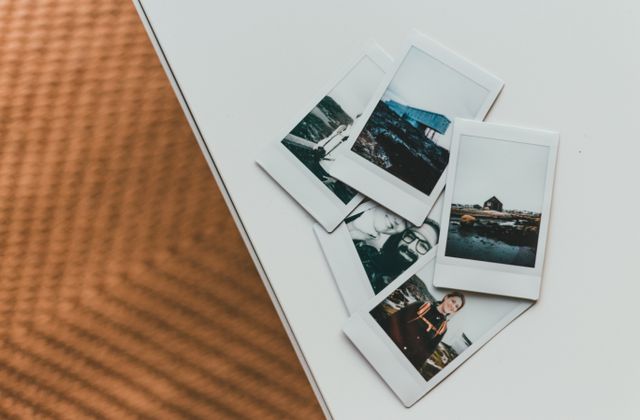 Printed instant photos spread across a table