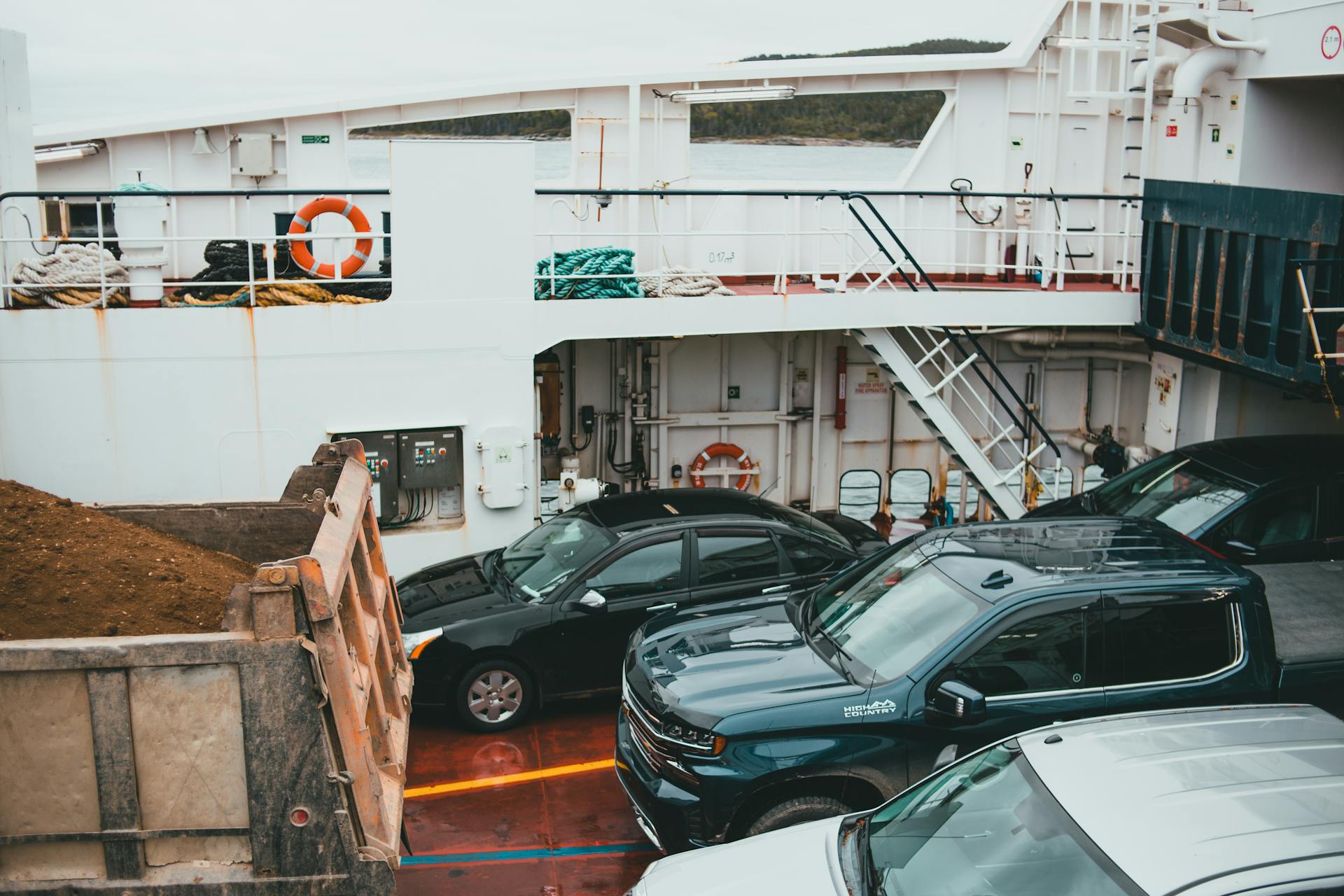 A view of vehicles parked on a ferry deck, showcasing transportation by sea.