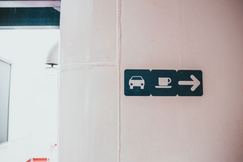 Pictogram direction signs mounted on a pale wall. Photo by Erik Mclean on Pexels.