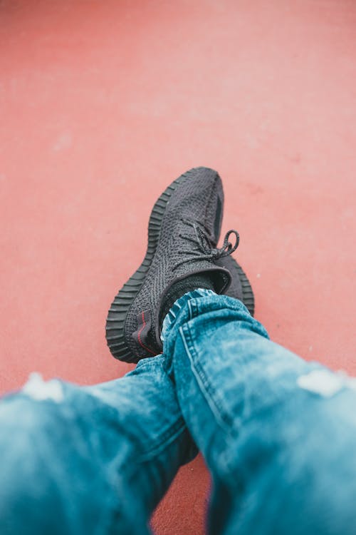 Free A Person in Denim Jeans Wearing Sneakers Stock Photo