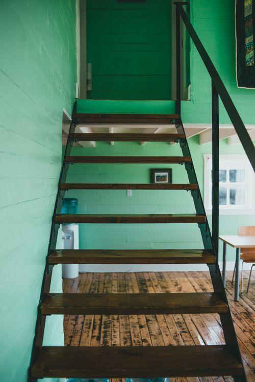 Free A charming blend of rustic and modern design featuring a wooden staircase and vibrant green walls. Stock Photo