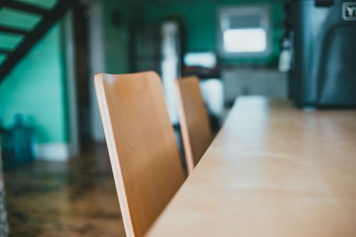 Free A cozy and vibrant dining space featuring modern wooden chairs and a table, perfect for home interiors. Stock Photo