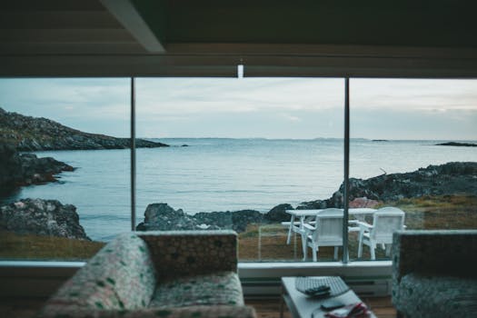 Peaceful ocean view through glass wall from comfortable living area.