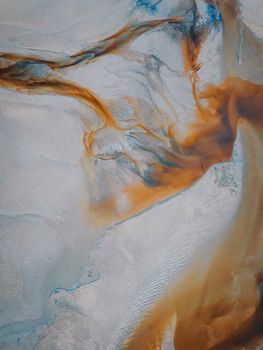 Stunning aerial abstract of natural water patterns in Terengganu, Malaysia, featuring swirling earth tones.