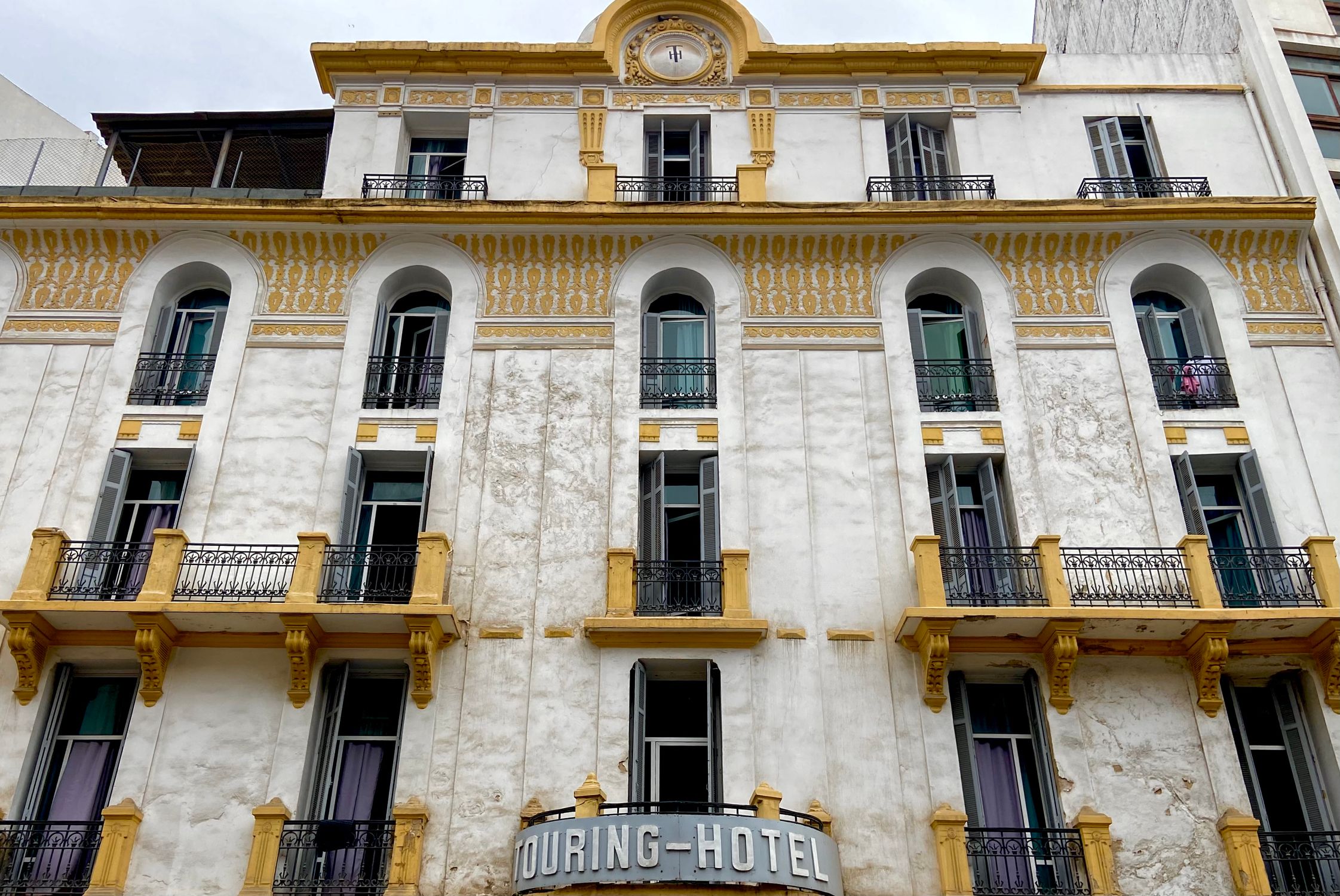 Captivating facade of a historic hotel in Casablanca featuring elegant balconies and detailed architecture.