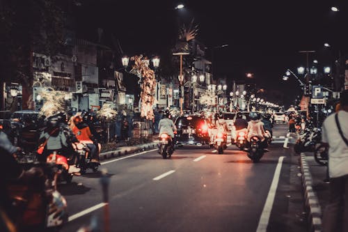 무료 밤 시간 동안 도로에서 오토바이를 타는 사람들 스톡 사진