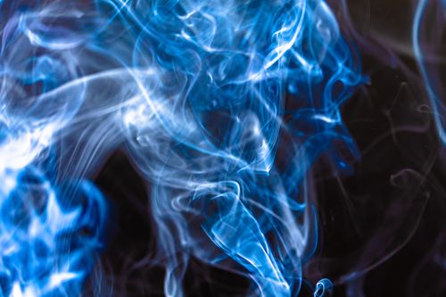 Free Abstract image of blue smoke swirling against a dark background, creating a mystical and ethereal effect. Stock Photo