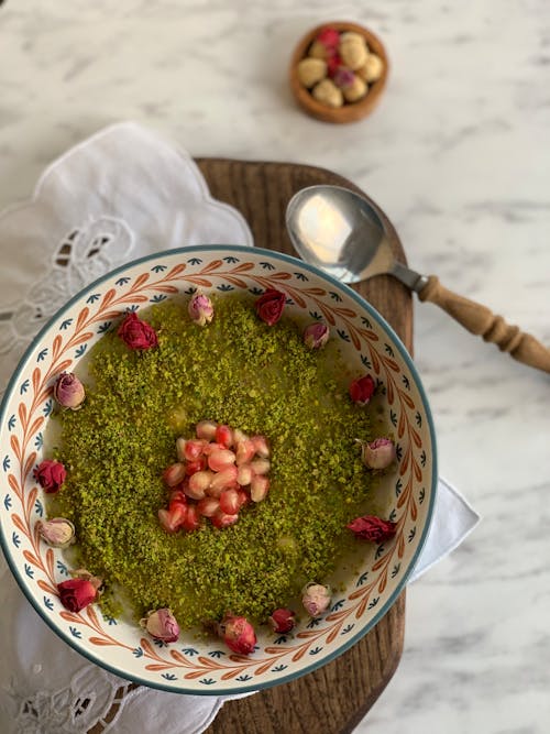 Green dish decorated with fruit slices near spoon