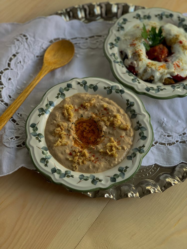 Plates Of Porridge And Meatballs With Sauce Near Spoon