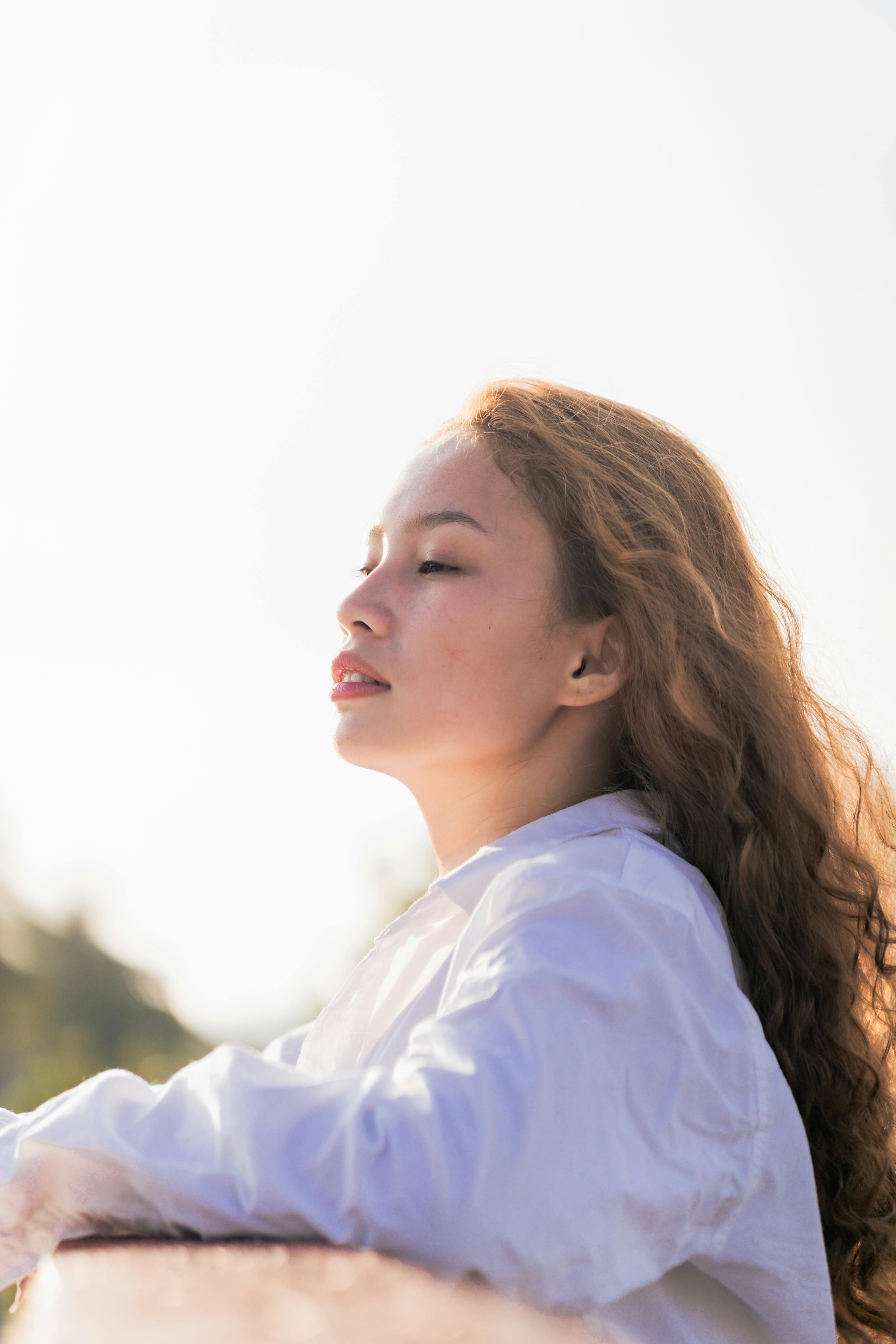 A serene portrait of a woman with closed eyes, enjoying the sunlight in Malita, Philippines.