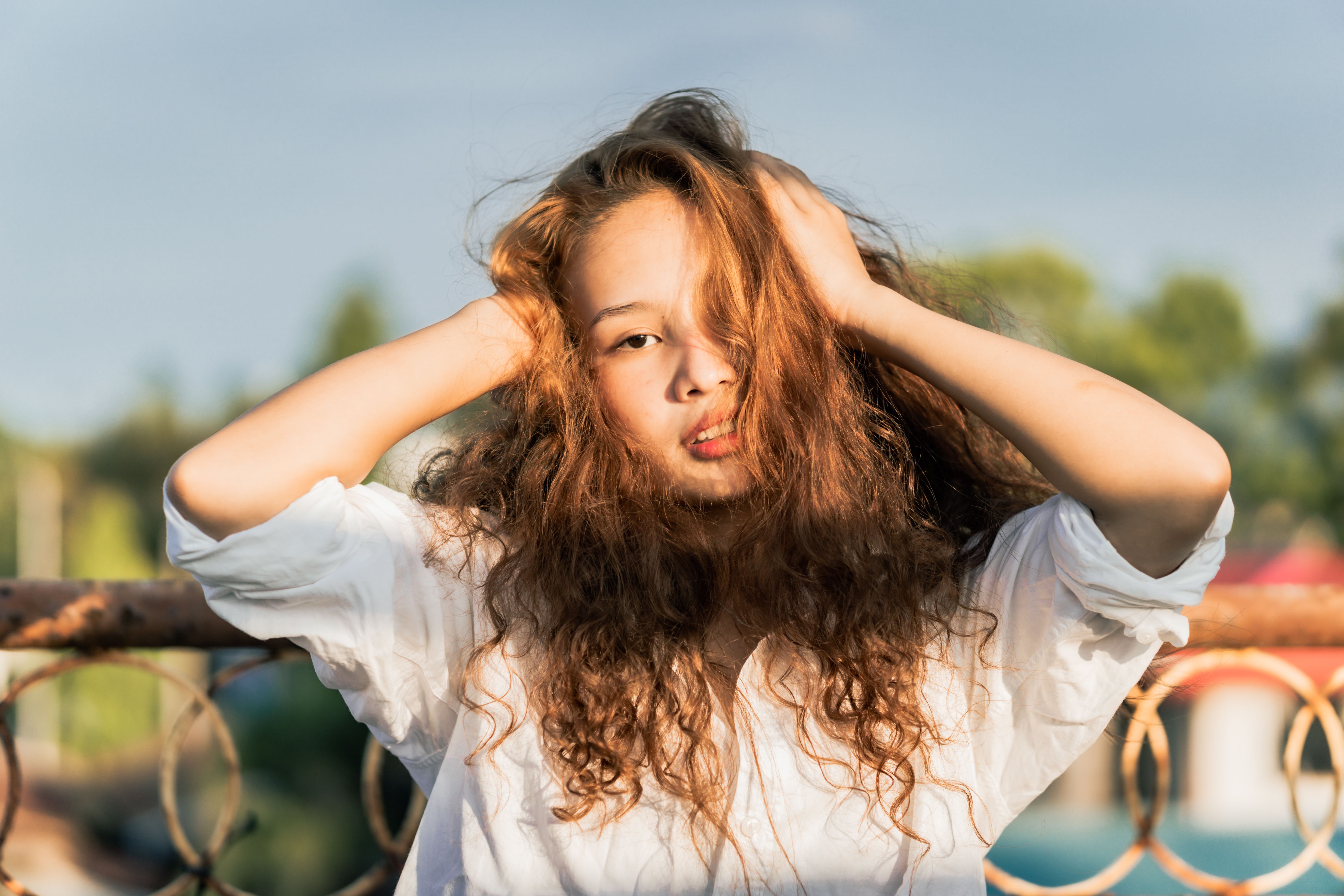 Portrait of a young woman with curly hair posing outdoors in Malita, Davao Region.