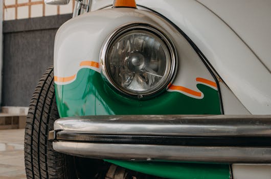 Detailed close-up of a vintage Volkswagen Beetle's headlight with colorful paint accents.